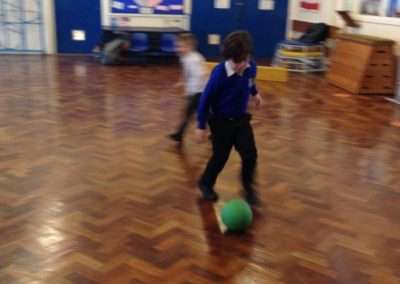 boys playing football in sports hall